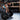 A woman standing crouched, her hands on a loaded barbell